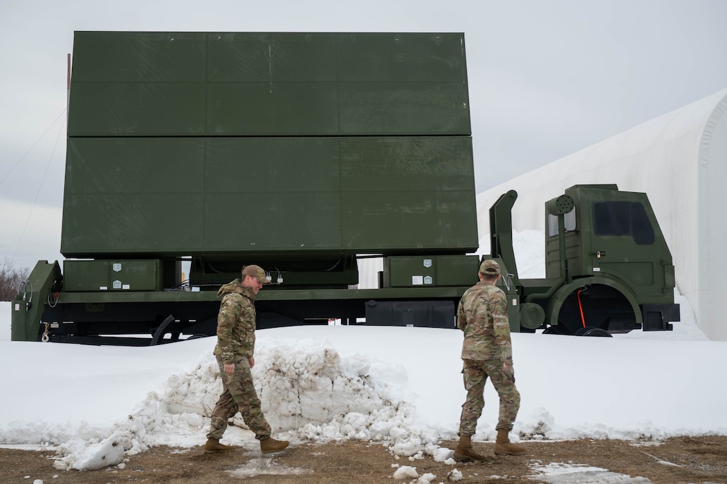 U.S. Air Force Staff Sgt. Kjell Olson, left, 354th Range Squadron plans and programs non-commissioned officer, and Tech. Sgt. Cameron Tolbert, 354th RANS quality assurance evaluator, walk in front of a range target at Eielson Air Force Base, Alaska, April 16, 2025.