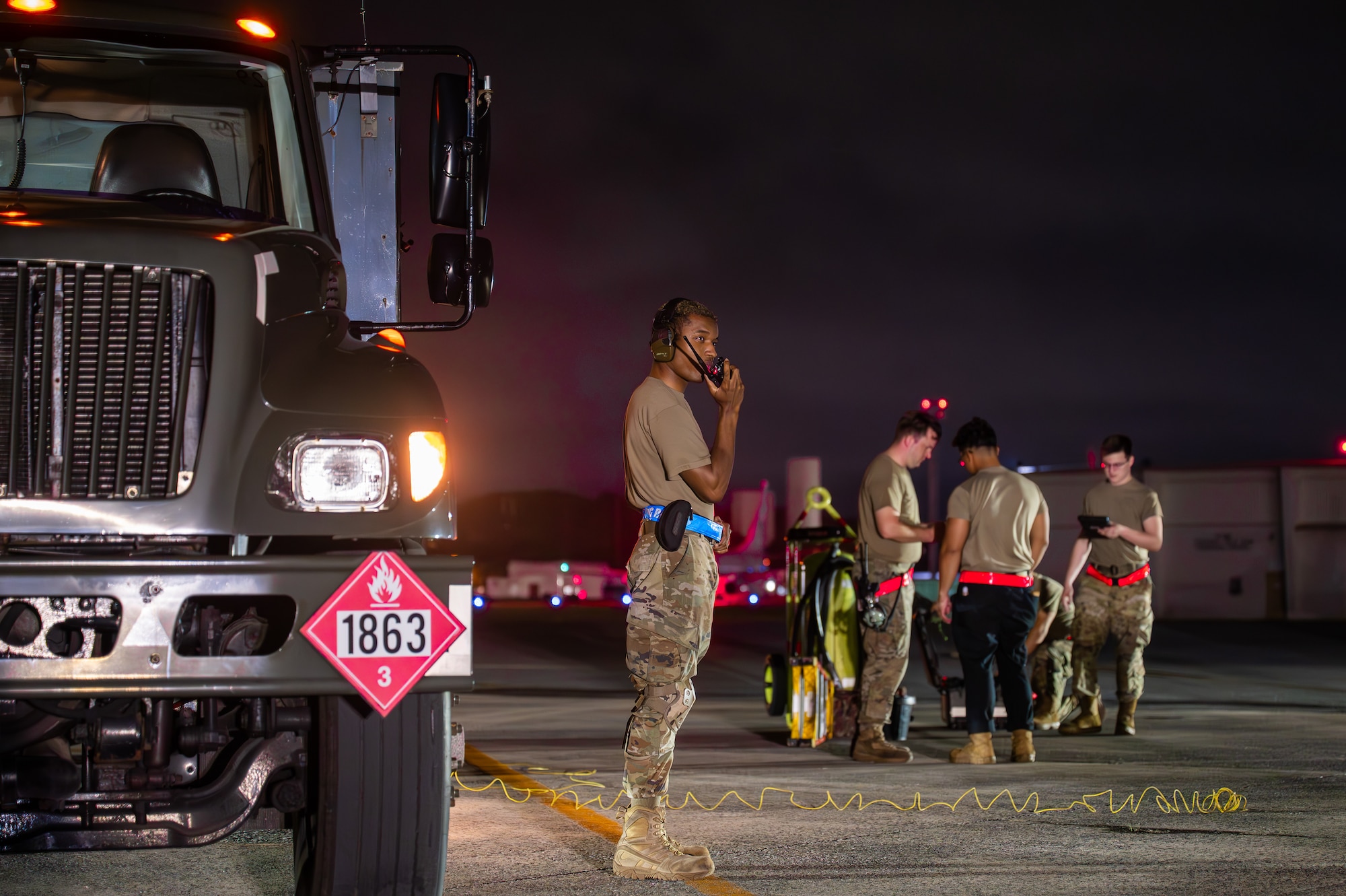 Service members service an aircraft.