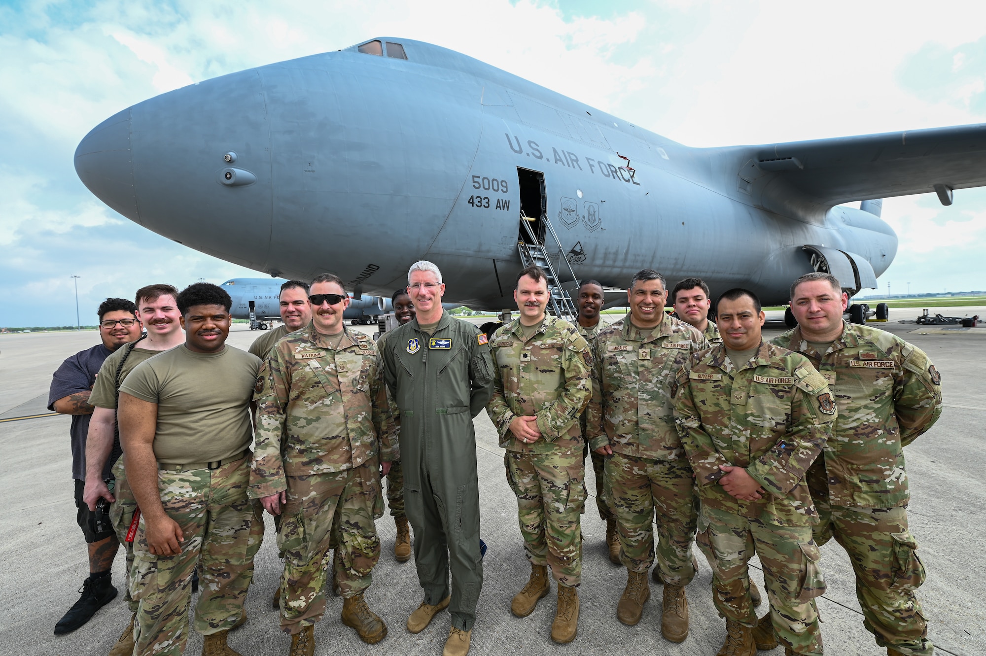 Col. Rick Kuehn, 512th Airlift Wing deputy wing commander, Lt. Col. Brandon Rodts, 433rd Maintenance Group deputy commander, Citizen Airmen from the 512th AW, and a 433rd AW civilian pose for a group photo during maintenance on a C-5M Super Galaxy at the 433rd Airlift Wing on Joint Base San Antonio-Lackland, Texas April 25, 2025.