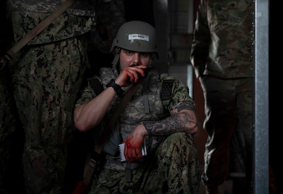 A military medical professional speaks into a radio.