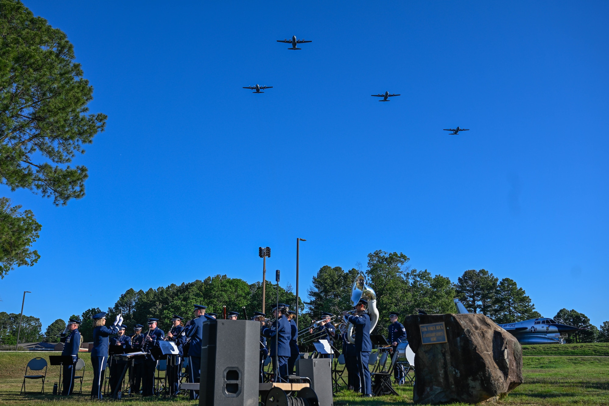 Band members watch aircraft fly.