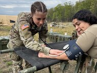 U.S. Army Spc. Caitlyn Morrison, left, and Spc. Maria Diaz, combat medics with the 108th Medical Company Area Support, 213th Regional Support Group, Pennsylvania National Guard practice medical skills during an exercise at Fort Indiantown Gap, Pennsylvania, May 3, 2025.