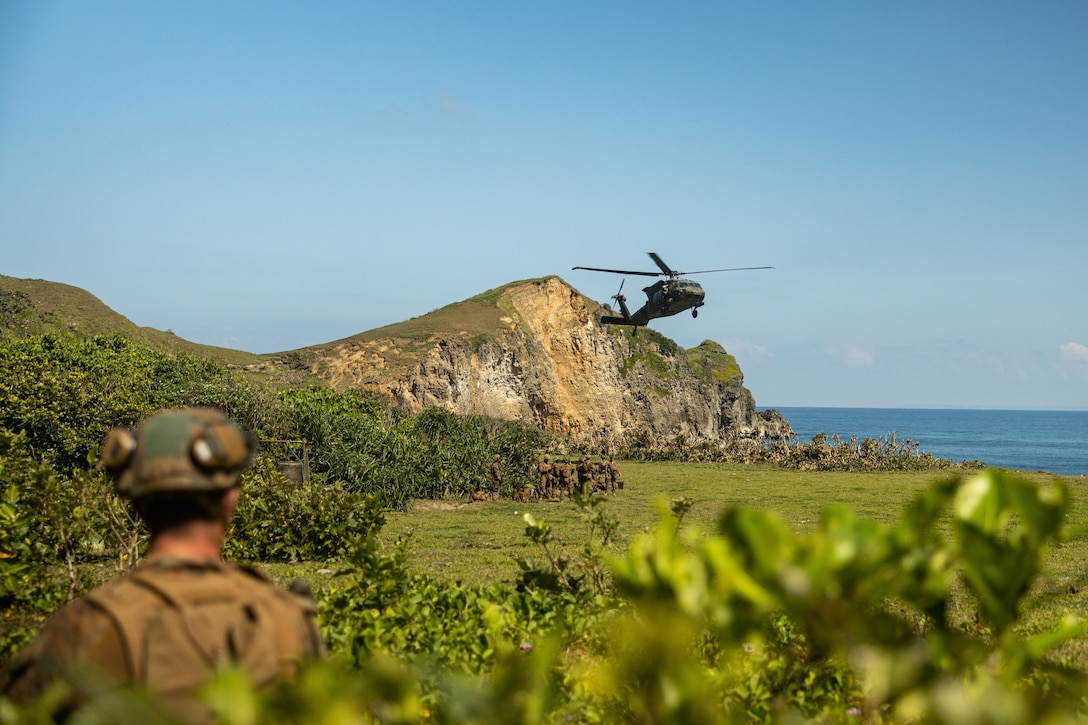 A U.S. Army UH-60 Black Hawk with 25th Combat Aviation Brigade, 25th Infantry Division, prepares to land while transporting U.S. Marines with 3d Littoral Combat Team, 3d Marine Littoral Regiment, 3d Marine Division, and Philippine Marines with Marine Battalion Landing Team 10, to the Batanes island chain for the Maritime Key Terrain Security Operations event during Exercise Balikatan 25 in the Philippines, April 24, 2025. Balikatan is a longstanding annual exercise between the Armed Forces of the Philippines and U.S. military designed to strengthen our ironclad alliance, improve our capable combined force, and demonstrate our commitment to regional security and stability. (U.S. Marine Corps photo by Cpl. Malia Sparks)