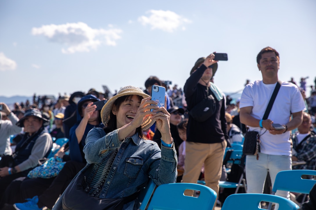 A guest observes a flight demonstration during the Japan Maritime Self-Defense Force-Marine Corps Air Station Iwakuni Friendship Day at MCAS Iwakuni, Japan, May 4, 2025. The JMSDF-MCAS Iwakuni Friendship Day is hosted annually to strengthen relationships with the host community and offer a cultural exchange that highlights the mutual support between the U.S. and Japan. (U.S. Marine Corps photo by Cpl. Colin Thibault)