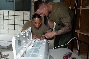 U.S. Air Force Tech. Sgt. Rebekaira Dickerson, left, 379th Expeditionary Civil Engineer Squadron dayshift noncommissioned officer in charge, and Senior Airman James Murray, right, 379th ECES heating, ventilation and air conditioning specialist, prepare an HVAC unit for installation within the U.S. Central Command area of responsibility, April 26, 2025. The HVAC team installed air conditioning units in preparation for the summer heat. (U.S. Air Force photo by Senior Airman Dieondiere Jefferies)