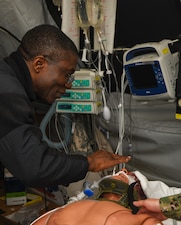 Lt. Jerome Madumelu performs first rites for a deceased simulated casualty during the Expeditionary Medical Facility Kilo (EMF-Kilo) Operational Readiness Exercise (ORE) on Fort McCoy, Wisconsin, April 30, 2025. EMF-Kilo is the readiness platform attached to Navy Medicine Readiness and Training Command Camp Lejeune and is comprised of approximately 400 personnel ready to deploy field hospital capabilities during humanitarian or combat mission.