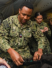 Hospital Corpsman Second Class Diquan Payton starts an IV for a simulated canine casualty during the Expeditionary Medical Facility Kilo (EMF-Kilo) Operational Readiness Exercise (ORE) on Fort McCoy, Wisconsin, April 30, 2025. EMF-Kilo is the readiness platform attached to Navy Medicine Readiness and Training Command Camp Lejeune and is comprised of approximately 400 personnel ready to deploy field hospital capabilities during humanitarian or combat mission.