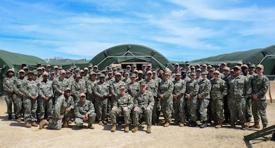 Expeditionary Medical Facility Kilo (EMF-Kilo) poses for a group photo during their Operational Readiness Exercise (ORE) on Fort McCoy, Wisconsin, April 30, 2025. EMF-Kilo is the readiness platform attached to Navy Medicine Readiness and Training Command Camp Lejeune and is comprised of approximately 400 personnel ready to deploy field hospital capabilities during humanitarian or combat mission.