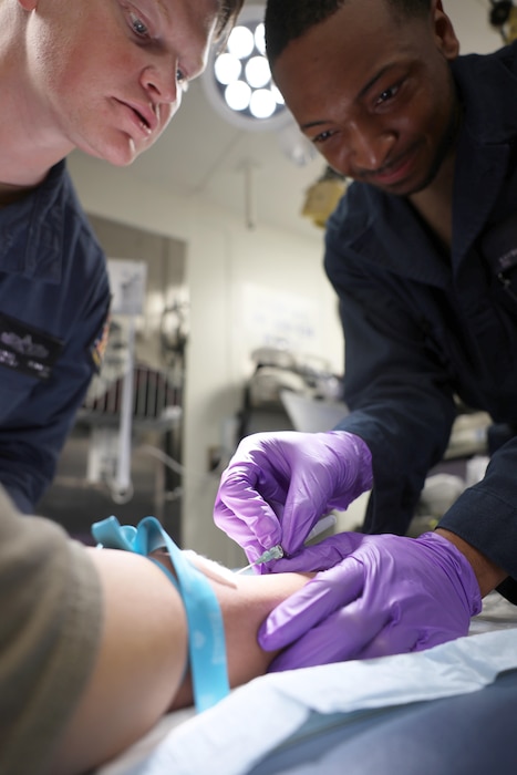 250429-N-YB423-1135 GULF OF AMERICA (April 29, 2025) Hospital Corpsman 1st Class Nathaniel Bennett (left), assigned to the Arleigh Burke-class guided-missile destroyer USS Gravely (DDG 107), provides medical training to Operations Specialist Seaman Kayshawn Ross, to maintain proficiency while underway in the Gulf of America, April 29, 2025. U.S. Navy assets are deployed under U.S. Northern Command’s maritime homeland defense authorities with a U.S. Coast Guard Law Enforcement Detachment embarked to enable maritime interdiction missions to prevent the flow of illegal drugs and other illegal activity. U.S. Northern Command is working together with the Department of Homeland Security to provide additional military forces and capabilities at the southern border. (U.S. Navy photo by Mass Communication Specialist 1st Class Ryan Williams)