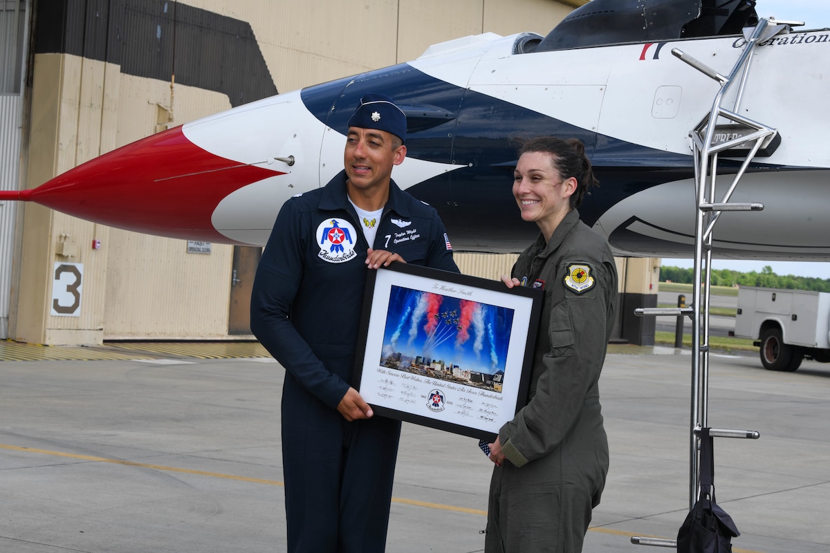 U.S. Air Force Lt. Col. Taylor Wight, left, Thunderbird Seven, Director of Operations for the U.S. Air Force Air Demonstration Squadron "Thunderbirds", presents Heather Smith, right, Hometown Hero participant, with memorabilia after completing an incentive flight at Seymour Johnson Air Force Base, North Carolina, May 2, 2025.  Smith is North Carolina’s teacher of the year and gets a one year sabbatical to travel throughout the state finding ways to improve education. (U.S. Air Force photo By Senior Airman Taylor Hunter)