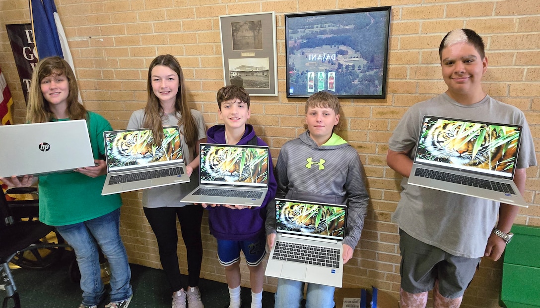 Five students hold laptop computers.