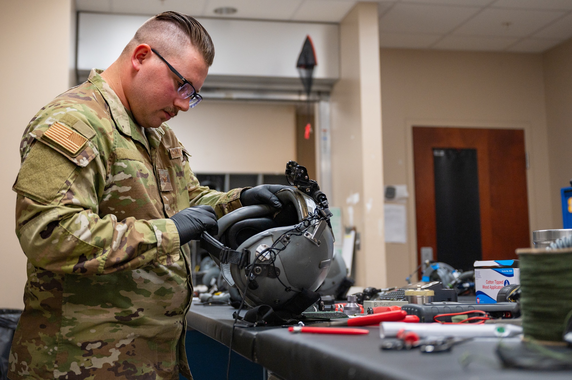 An Air Force Aircrew Flight Equipment technician performs maintenance on a flight helmet at Hurlburt Field.