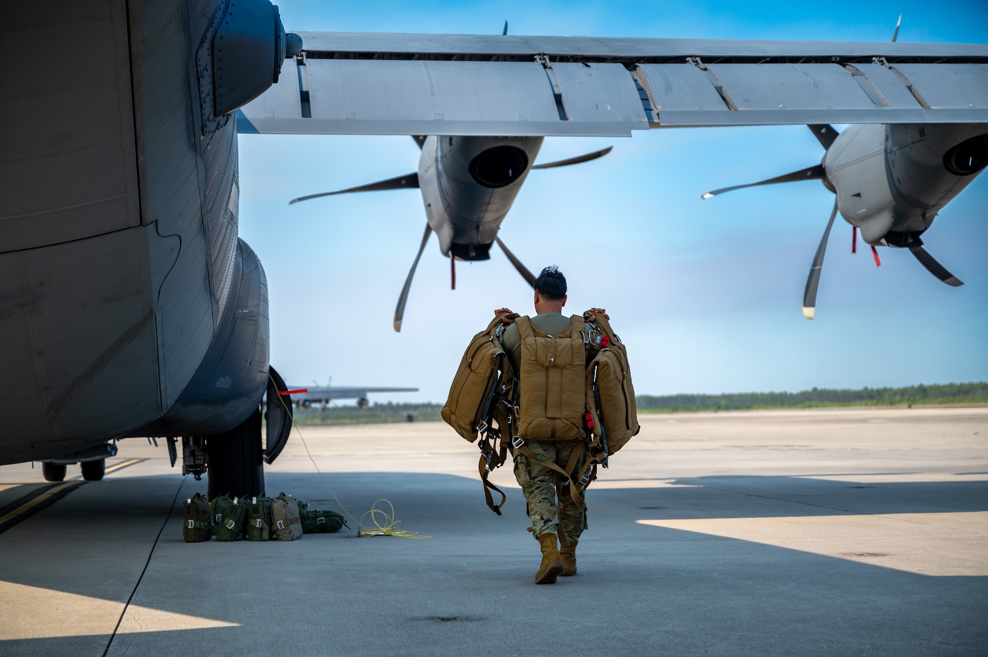 An Air Force Aircrew Flight Equipment technician carries parachutes to an aircraft at Hurlburt Field.