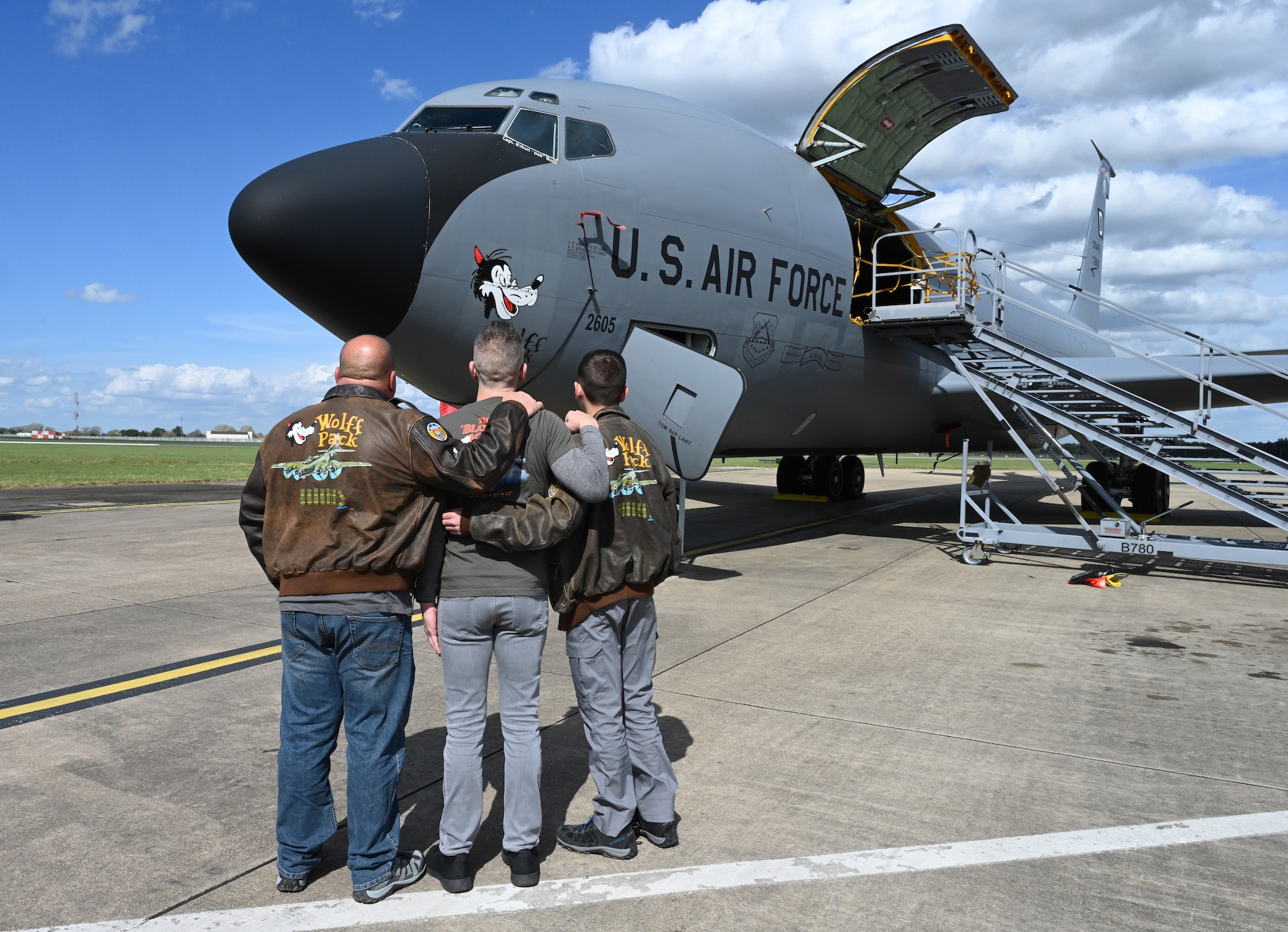 Randy Wolff, left, and Jeffrey Paul Wolff, center, both grandsons of World War II and 100th Bomb Group veteran Capt. Robert “Bob” Wolff, and Austin Wolff, son of Randy and great-grandson of Bob, take an emotional look at the “Wolff Pack” nose art adorning a KC-135 Stratotanker during a visit to RAF Mildenhall, England, April 16, 2025. The nose art is one of the 100th Air Refueling Wing’s fleet of legacy nose art and honors Capt. Wolff and his crew. The family visited from California and North Carolina and brought some of the veteran’s ashes to lay to rest in the chapel at Thorpe Abbotts. (U.S. Air Force photo by Karen Abeyasekere)
