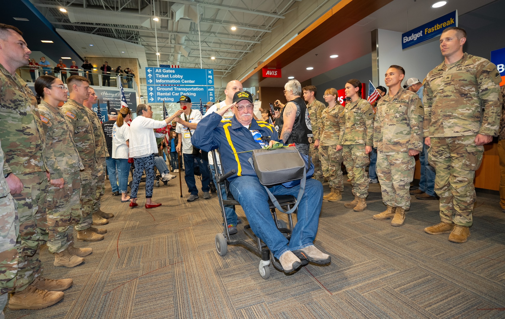 A Vietnam veteran renders a salute from his wheelchair as he passes through the honor corridor at the Medford Airport, Medford, Ore., May 4, 2025. Oregon Army National Guard soldiers and Patriot Guard Riders formed the corridor to welcome veterans returning from an Honor Flight trip to Washington, D.C., where they visited military memorials honoring their service.