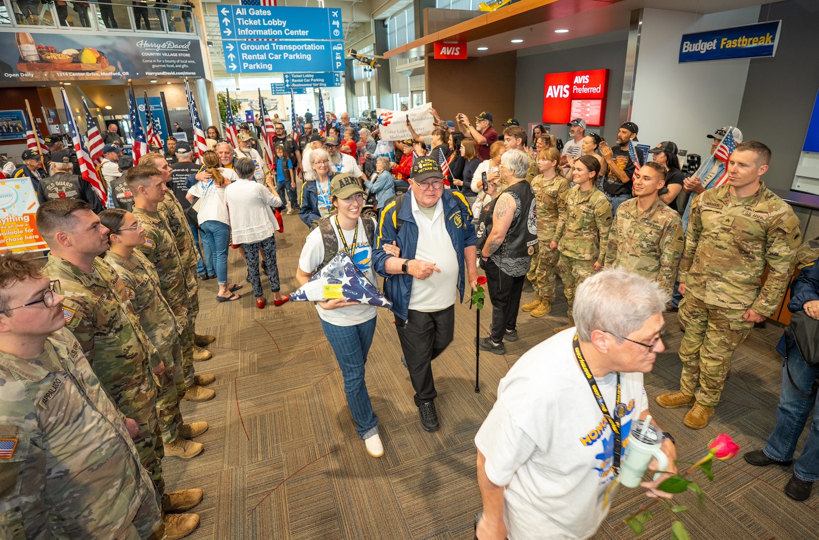 Oregon Army National Guard soldiers from the 1st Battalion, 186th Infantry Regiment stand in formation alongside Patriot Guard Riders to create a welcome corridor for veterans returning from Honor Flight of Oregon at the Medford Airport, Medford, Ore., May 4, 2025. The four-day trip allowed veterans to visit war memorials in the nation's capital, showing them the nation's gratitude for their service.