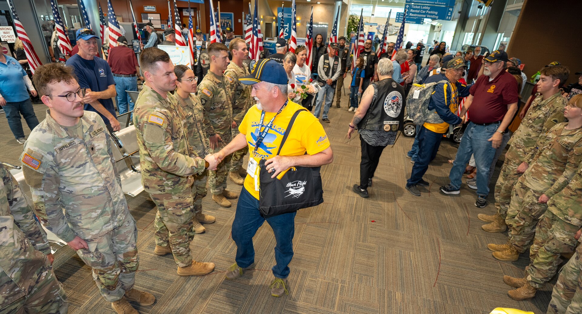 Pete Pringle, a leader with Honor Flight of Oregon, shakes hands with Sgt. 1st Class Jase Deemer, Headquarters and Headquarters Company Readiness NCO, 1st Battalion, 186th Infantry Regiment, at the Medford Airport, Medford, Ore., May 4, 2025. Sgt. 1st Class Deemer coordinated the Oregon Army National Guard support for the veteran welcome event, which honored veterans returning from visiting military memorials in Washington, D.C.