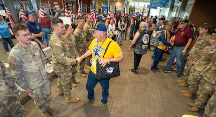 Pete Pringle, a leader with Honor Flight of Oregon, shakes hands with Sgt. 1st Class Jase Deemer, Headquarters and Headquarters Company Readiness NCO, 1st Battalion, 186th Infantry Regiment, at the Medford Airport, Medford, Ore., May 4, 2025. Sgt. 1st Class Deemer coordinated the Oregon Army National Guard support for the veteran welcome event, which honored veterans returning from visiting military memorials in Washington, D.C.