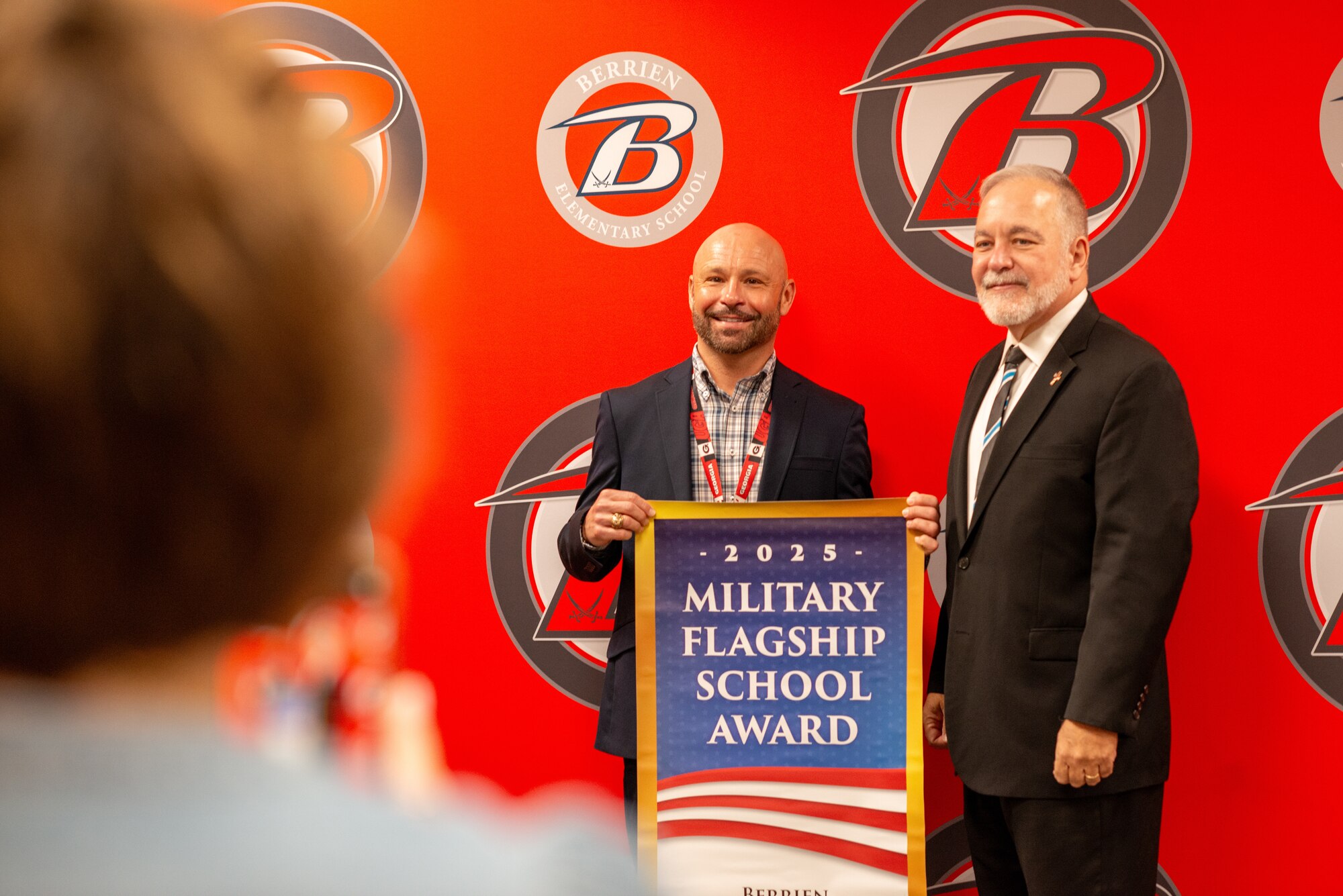 Representative stands with school principal.