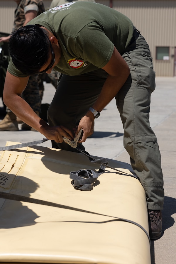 U.S. Marine Corps Sgt. Wilfredo Huitroncampista, a bulk fuel specialist with Marine Wing Support Squadron 373, Marine Air Control Group 38, 3rd Marine Aircraft Wing, disassembles a collapsible fuel tank during Tactical Air-Ground Refueling Sysytem New Equipment Training at Marien Air Station Miramar, California, April 24, 2025.  The TAGRS, an expeditionary Marine Corps-exclusive asset, is a compact mobile refueling system designed to expand the capabilities of Marine Corps’ Forward Arming and Refueling Points and Expeditionary Advanced Base Operations. TAGRS support refueling operations in forward areas and remote locations. (U.S. Marine Corps photo by Lance Cpl. Samantha Devine)