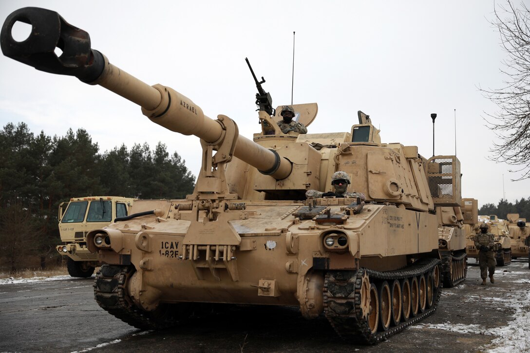 Soldiers ride in a beige Paladin