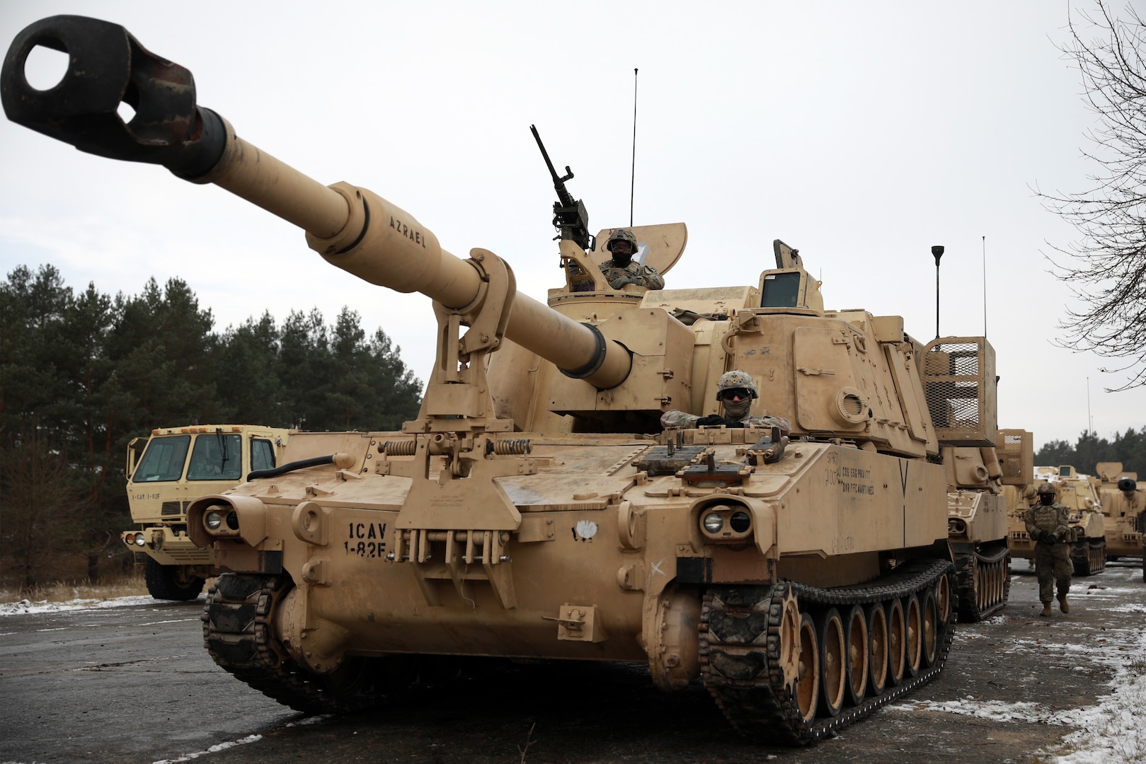 Soldiers ride in a beige Paladin