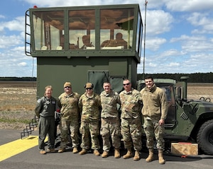 From left, U.S. Air Force Col. Kathleen Hasson, 305th Air Mobility Wing commander, Tech. Sgts. Christopher Roth, Michael Sabo, and Stephen Snyder, Master Sgt. John Babl and Senior Airman Ethan Kubat, 258th Combat Airfield Operations Squadron Mobile Special Navigational Aid-7 personnel, pose for a photo in front of the MSN-7 tower at Joint Base McGuire-Dix-Lakehurst, N.J., April 8, 2025. In a display of Total Force Integration, active-duty Airmen, Sailors and Air National Guard teams successfully deployed and activated the MSN-7 tower at Lakehurst’s Maxwell Field while the main tower underwent refurbishment allowing for uninterrupted support to mission readiness and operational capability. (U.S. Air Force photo by Staff Sgt. Nicholas Nalback)