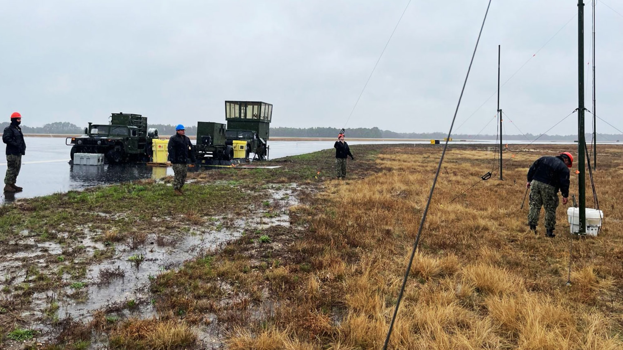 U.S. Navy Ground Equipment Maintenance Division and 258th Combat Airfield Operations Squadron personnel set up Mobile Special Navigational Aid-7 tower during inclement weather at Joint Base McGuire-Dix-Lakehurst, N.J. April 6, 2025. In a display of Total Force Integration, active-duty Airmen, Sailors and Air National Guard teams successfully deployed and activated the MSN-7 tower at Lakehurst’s Maxwell Field while the main tower underwent refurbishment allowing for uninterrupted support to mission readiness and operational capability. (U.S. Navy photo by Electronics Technician 1st Class Michael Easi)