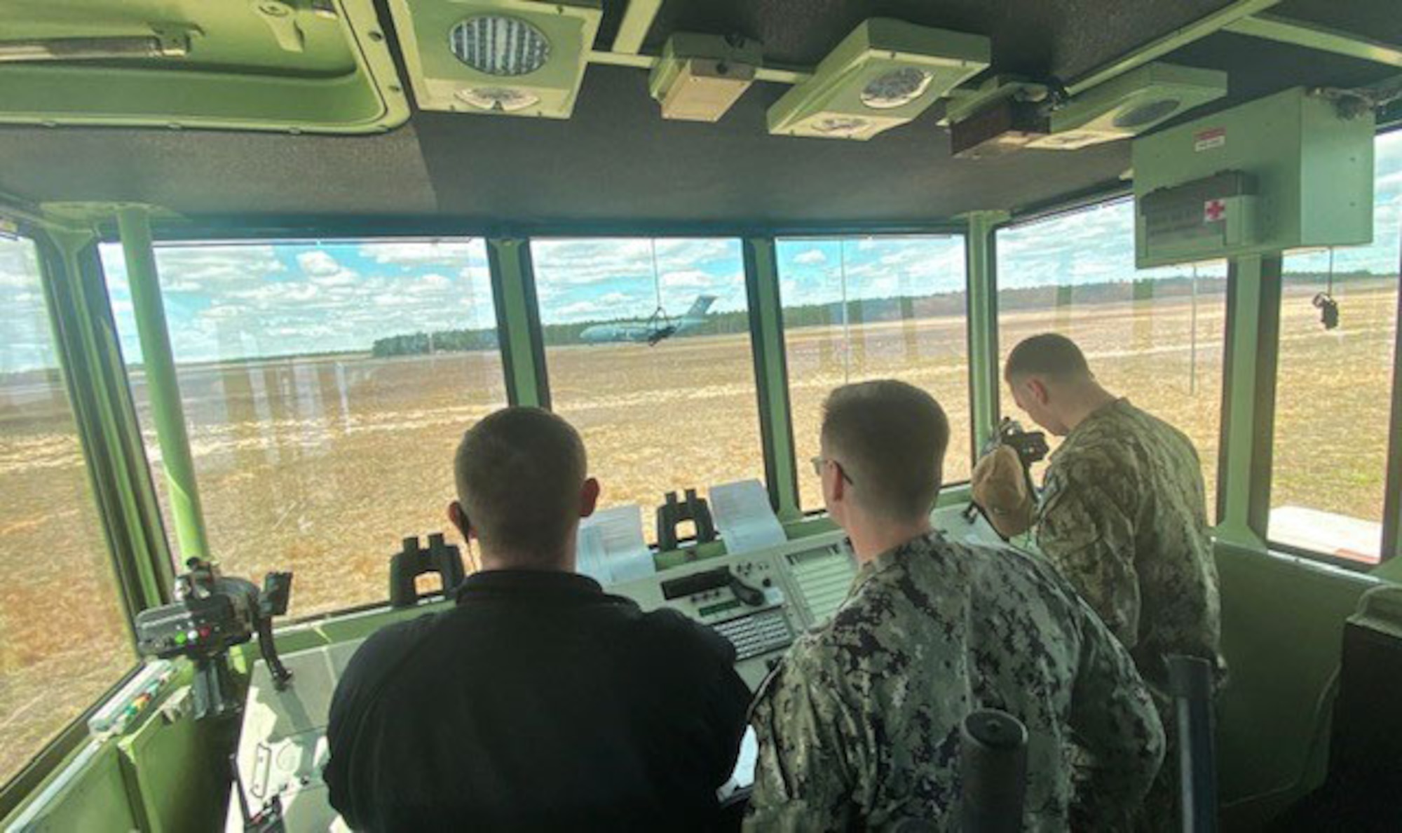 U.S. Navy Petty Officer 1st Class Tyler Mohnacky, Petty Officer 2nd Class Henry Waterman and Petty Officer 1st Class Adam Bradberry, 305th Operations Support Squadron air traffic controllers, oversee aircraft operations from inside the Mobile Special Navigational Aid-7 tower at Joint Base McGuire-Dix-Lakhurst, N.J., April 8, 2025. In a display of Total Force Integration, active-duty Airmen, Sailors and Air National Guard teams successfully deployed and activated the MSN-7 tower at Lakehurst’s Maxwell Field while the main tower underwent refurbishment allowing for uninterrupted support to mission readiness and operational capability. (U.S. Air Force photo by Tech. Sgt. Stephen Snyder)