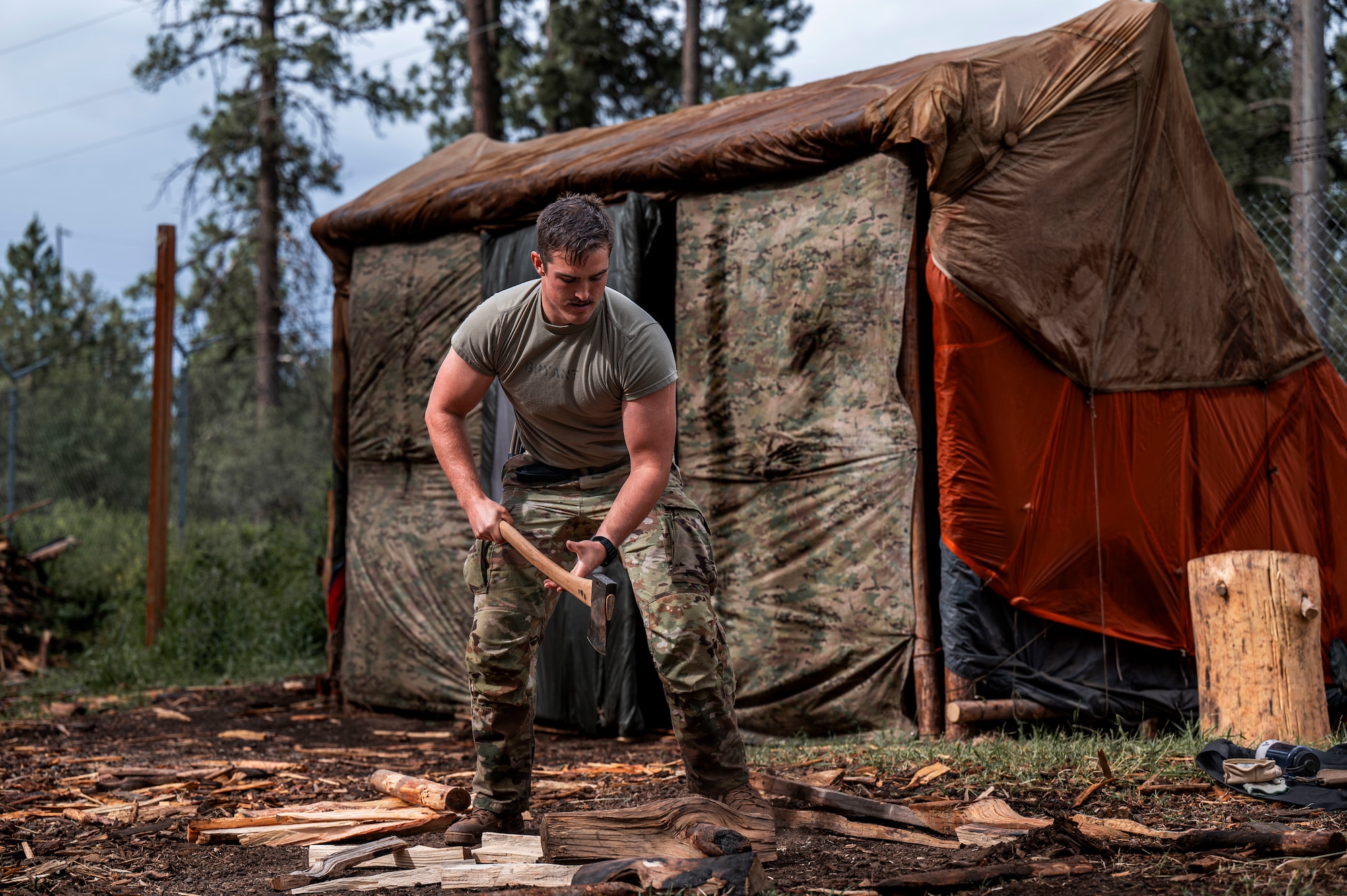 A U.S. Air Force student with the 66th Training Squadron Survival, Evasion, Resistance and Escape  pre-team 25-A cuts wood during a fire craft exercise at Fairchild Air Force Base, Washington, June 27, 2024. Throughout the training pipeline, SERE students are taught techniques to be able to utilize their surroundings in order to survive. Upon graduation, SERE specialists utilize their skills to train at-risk personnel how to survive potential scenarios like isolation or capture. (U.S. Air Force photo by Senior Airman Tiffany Del Oso)