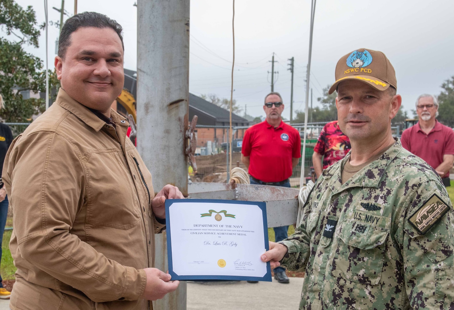 (right) NSWC PCD Commanding Officer Capt. Paul Stence, Jr., awards Dr. Luis Gely, NSWC PCD supervisory contracting officer, the Department of the Navy Civilian Service Achievement Medal, Mar.14. His dedicated effort was recognized for providing acquisition professionals with improved resources and processes directly supports the warfighter's littoral dominance from seabed to space. (U.S. Navy photo by Eddie Green)