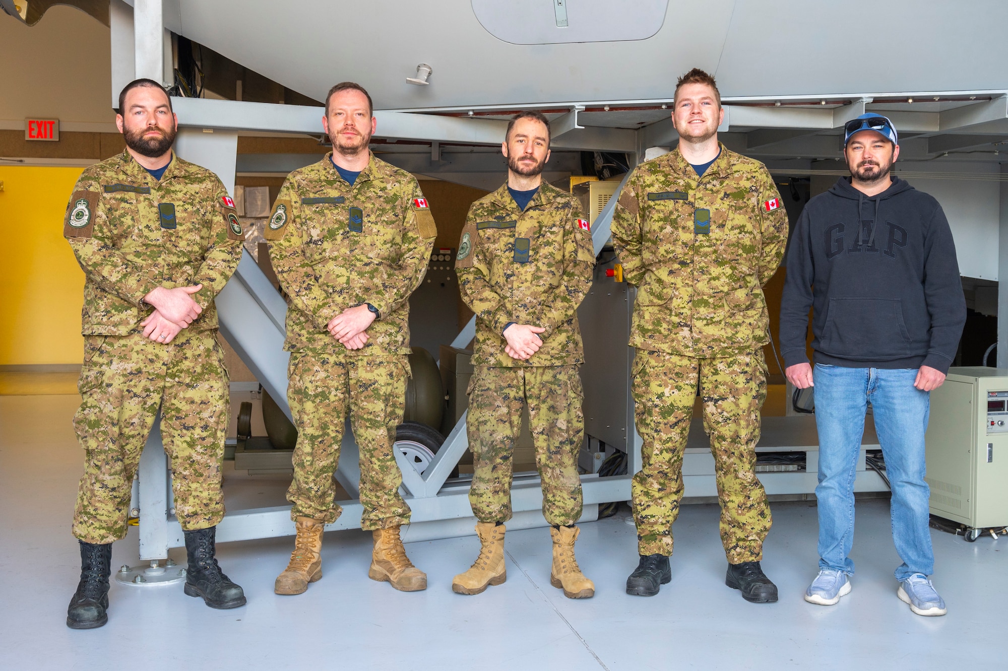 Royal Canadian Air Force Airmen stand together inside the 373rd Training Squadron, Detachment 12, building at Joint Base Lewis-McChord, Washington, April 24, 2025.