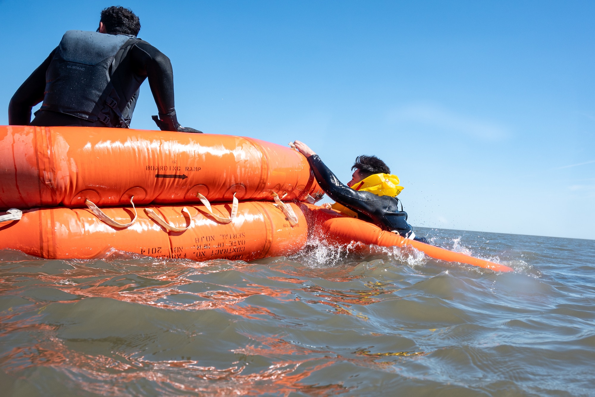 U.S. Air Force Staff Sgt. Christopher Maldonado, 436th Operational Support Squadron Survival, Evasion, Resistance and Escape specialist, encourages an Airman climbing into a raft during the Water Survival Preparation course at Bowers Beach, Delaware, April 29, 2025. The Water Survival Preparation course reinforces Airmen’s knowledge and best practices for survival in the event of a downed aircraft over open water.