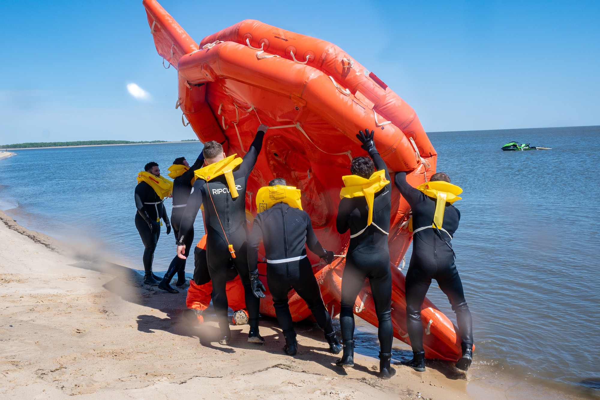 Team Dover Airmen flip a 20-person life raft during their Water Survival Preparation course at Bowers Beach, Delaware, April 29, 2025. The Water Survival Preparation course reinforces Airmen’s knowledge and best practices for survival in the event of a downed aircraft over open water.