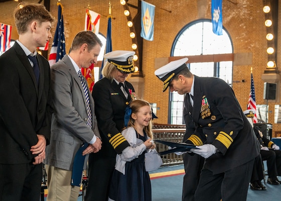 (250411-N-IX644-1007) ANNAPOLIS, Md. Rear Adm. Rick Freedman, right, Navy Deputy Surgeon General and Deputy Chief, Bureau of Medicine and Surgery, presents Ella Doye with a letter of appreciation during Capt. Lydia Doye’s retirement ceremony in Dahlgren Hall at the United States Naval Academy, April 11, 2025. Doye served in the Navy for 27 years, building, training, and developing Sailors as a pilot and later as a human resources officer. (U.S. Navy photo by Mass Communication Specialist 2nd Class Sasha Ambrose)