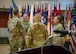 Newly designated Command Sergeant Major Timothy McGuire accepts the unit colors as outgoing CSM Michael Starrett and G-3 Sergeant Major Nicola Felder look on during the Change of Responsibility ceremony at the Eisenhower Conference and Catering Center April 16, 2025.