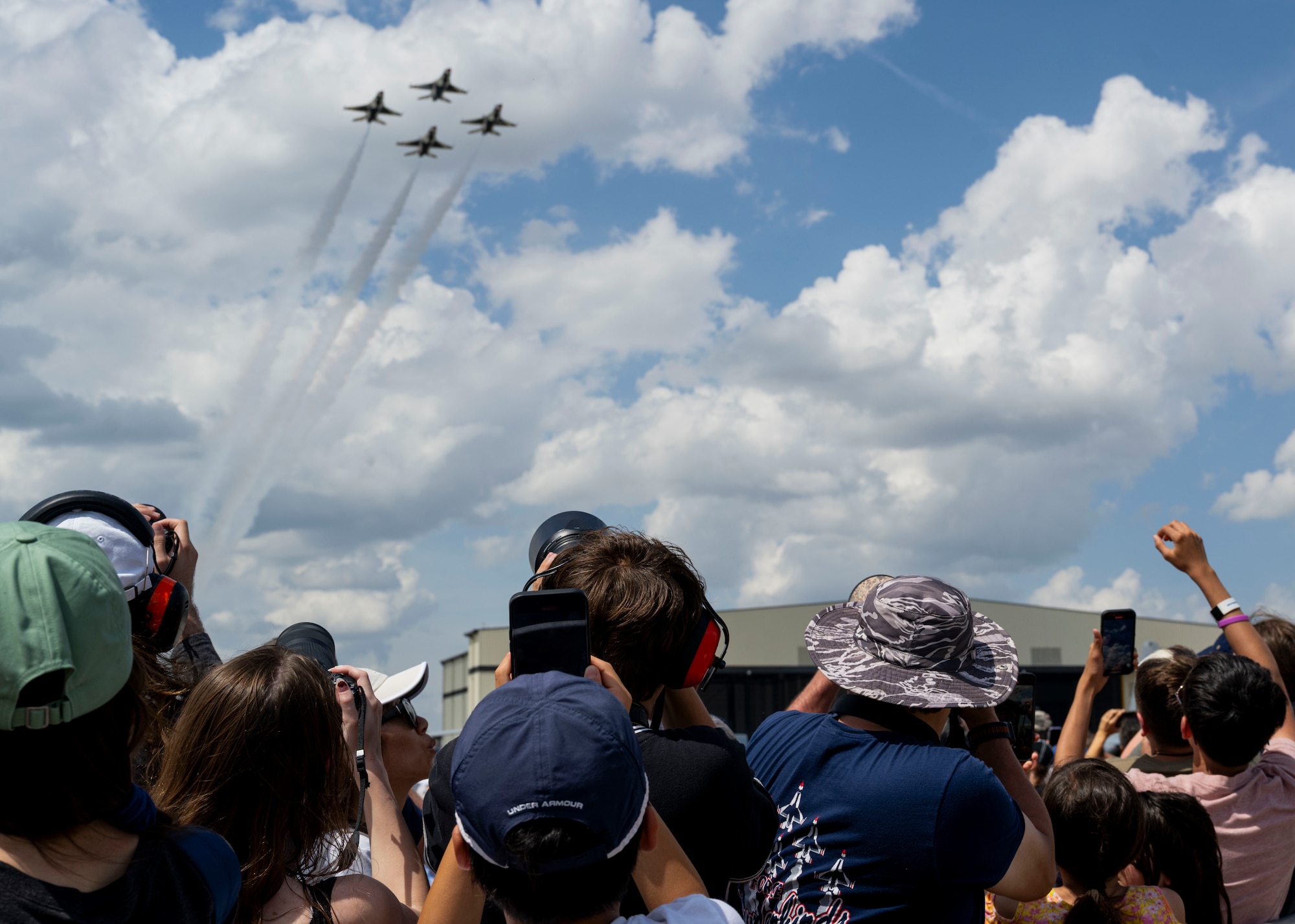 Members of the local populace watch the U.S. Air Force Thunderbirds perform during the Wings Over Wayne Open House 2025, at Seymour Johnson Air Force Base, North Carolina, May 3, 2025. The “Thunderbirds” performances support Air Force recruiting efforts and foster patriotism by showcasing airpower to the public. (U.S. Air Force photo by Staff Sgt. David Lynn)
