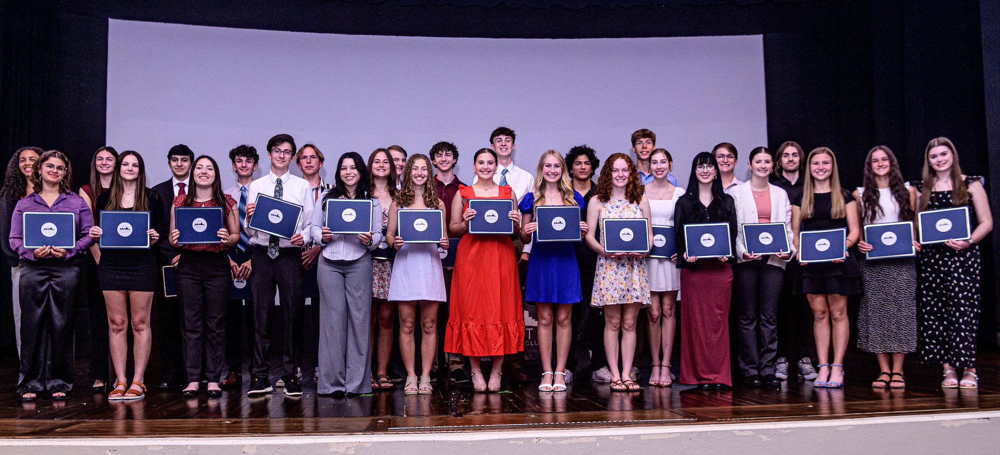 Groups of students pose for group photo with scholarships.