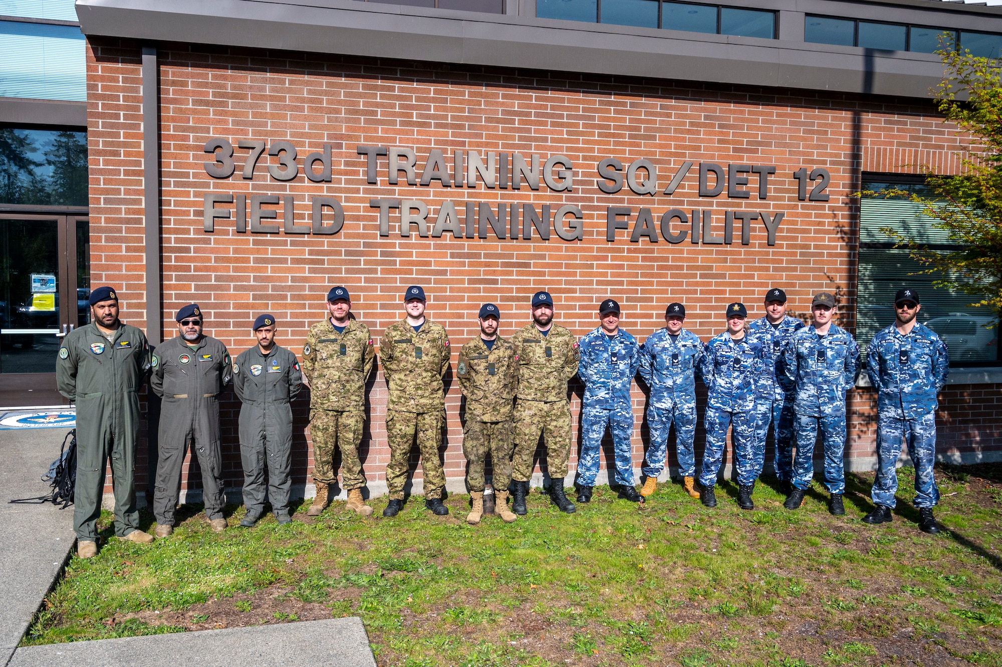 Kuwait Air Force Airmen, left, Royal Canadian Air Force Airmen, center, and Royal Australian Air Force Airmen stand together outside the 373rd Training Squadron, Detachment 12, at Joint Base Lewis-McChord, Washington, April 24, 2025.