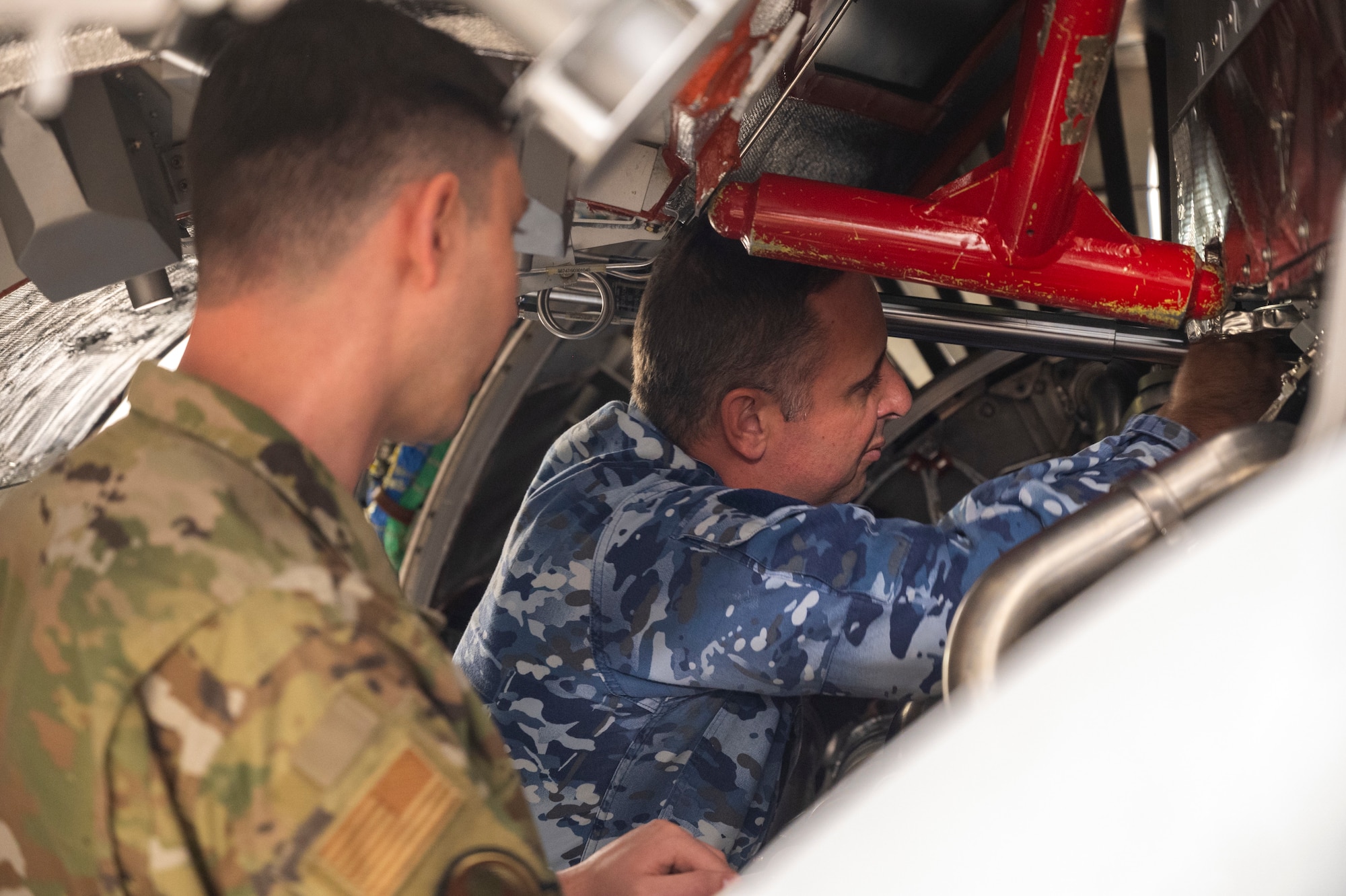 U.S. Air Force Staff Sgt. Tyler Covey, 373rd Training Squadron Detachment 12 propulsion instructor, and Royal Australian Air Force Sgt. Steven Ferrie, 36th Squadron aircraft technician, conduct aircraft maintenance training on a 373rd TRS, Det. 12, C-17 Globemaster III engine simulator at Joint Base Lewis-McChord, Washington, April 24, 2025.