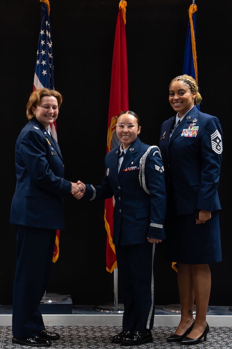 U.S. Air Force Senior Airman Raine Lo, class 24-Bravo ceremonial guardsman, receives the Base Honor Guard coin from Col. Angelina Maguinness, 17th TRW commander, and Chief Master Sgt. Khamillia Washington, 17th TRW command chief, during the Goodfellow Base Honor Guard class 25-Alpha graduation ceremony at the Powell Event Center, Goodfellow Air Force Base, Texas, May 2, 2025. Ceremonial guardsmen attached to class 24-Bravo were recognized for completing over 100 details, accruing 201 mission hours, and traveling 5,600 miles across 28 counties of West Texas in support of the 17th Training Wing’s Congressional Funeral Honors program. (U.S. Air Force photo by Airman 1st Class Brian Lummus)