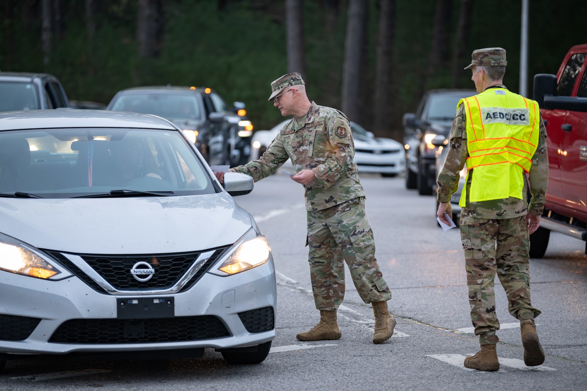 Arnold Engineering Development Complex Commander Col. Grant Mizell, right, and AEDC Test Support Division Chief Col. Eric Withrow participate in a gate wave on the morning April 3, 2025, at Arnold Air Force Base, Tenn. The gate wave was one of various events coordinated by the Arnold AFB Sexual Assault Prevention and Response office to coincide with Sexual Assault Awareness and Prevention Month, recognized each April. During the gate wave, base leadership and the SAPR team members greeted team members as they entered through the gate, handing out more than 600 teal ribbon pins and SAAPM information. Arnold AFB is the headquarters of AEDC. (U.S. Air Force photo by Keith Thornburgh)
