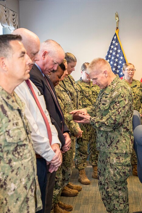 250506-N-KC192-1010 PORTSMOUTH, Va. (May 6, 2025) Capt. Ebony Ferguson, the operations department head assigned to Naval Medical Forces Atlantic (NMFL), has her hands prayed over by Capt. William Hlavin, the regional chaplain assigned to NMFL, during a blessing of the hands ceremony held during National Nurses Week for NMFL nurses and staff as all are a part of the healing team onboard Naval Support Activity (NSA) Hampton Roads - Portsmouth Annex, May 6, 2025. Blessing of the hands is a moment of celebration and thanksgiving in recognition of a caregiver’s hands with oils or water and symbolizes how hands are used to deliver care and compassion. The Blessing of the Hands symbolizes the sacred role of healers and connects to Spiritual Readiness by affirming a caregiver’s sense of purpose, compassion, and inner strength to serve others with honor and resilience. (U.S. Navy photo by Mass Communication Specialist 2nd Class Levi Decker)