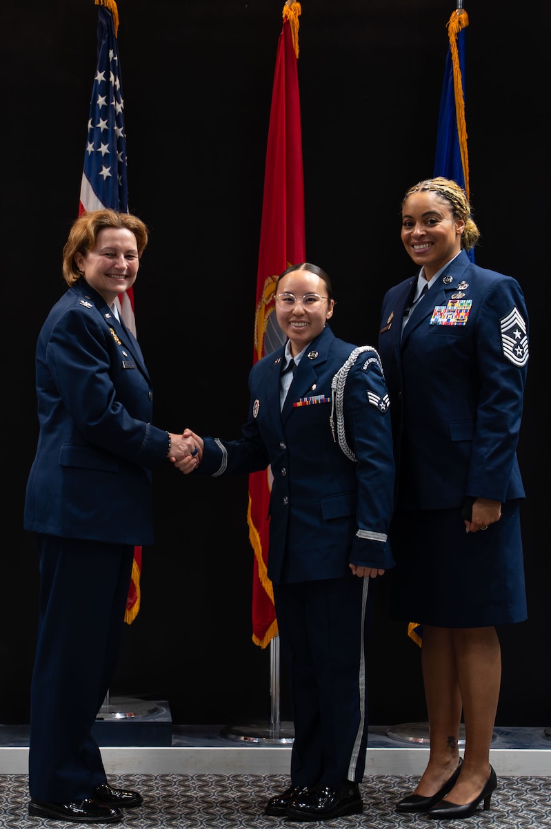 U.S. Air Force Senior Airman Raine Lo, class 24-Bravo ceremonial guardsman, receives the Base Honor Guard coin from Col. Angelina Maguinness, 17th TRW commander, and Chief Master Sgt. Khamillia Washington, 17th TRW command chief, during the Goodfellow Base Honor Guard class 25-Alpha graduation ceremony at the Powell Event Center, Goodfellow Air Force Base, Texas, May 2, 2025. Ceremonial guardsmen attached to class 24-Bravo were recognized for completing over 100 details, accruing 201 mission hours, and traveling 5,600 miles across 28 counties of West Texas in support of the 17th Training Wing’s Congressional Funeral Honors program. (U.S. Air Force photo by Airman 1st Class Brian Lummus)