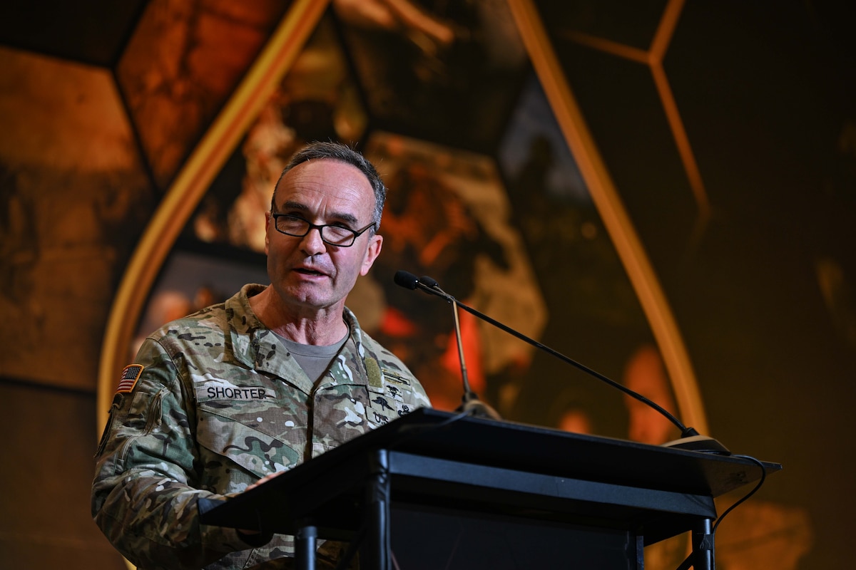 A man speaks from a stage.