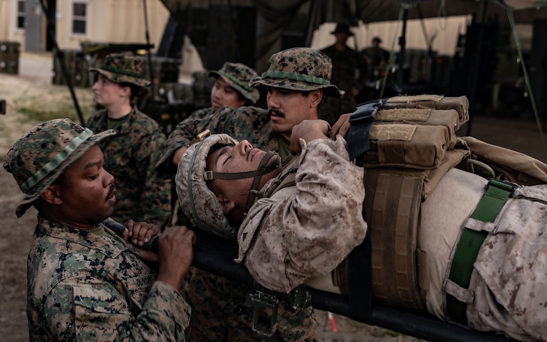 U.S. Navy Sailors with 1st Medical Battalion, 1st Marine Logistics Group, carry a patient into a Role 2 care center during a notional casualty scenario, part of a certification exercise on Marine Corps Base Camp Pendleton, California, April 22, 2025.