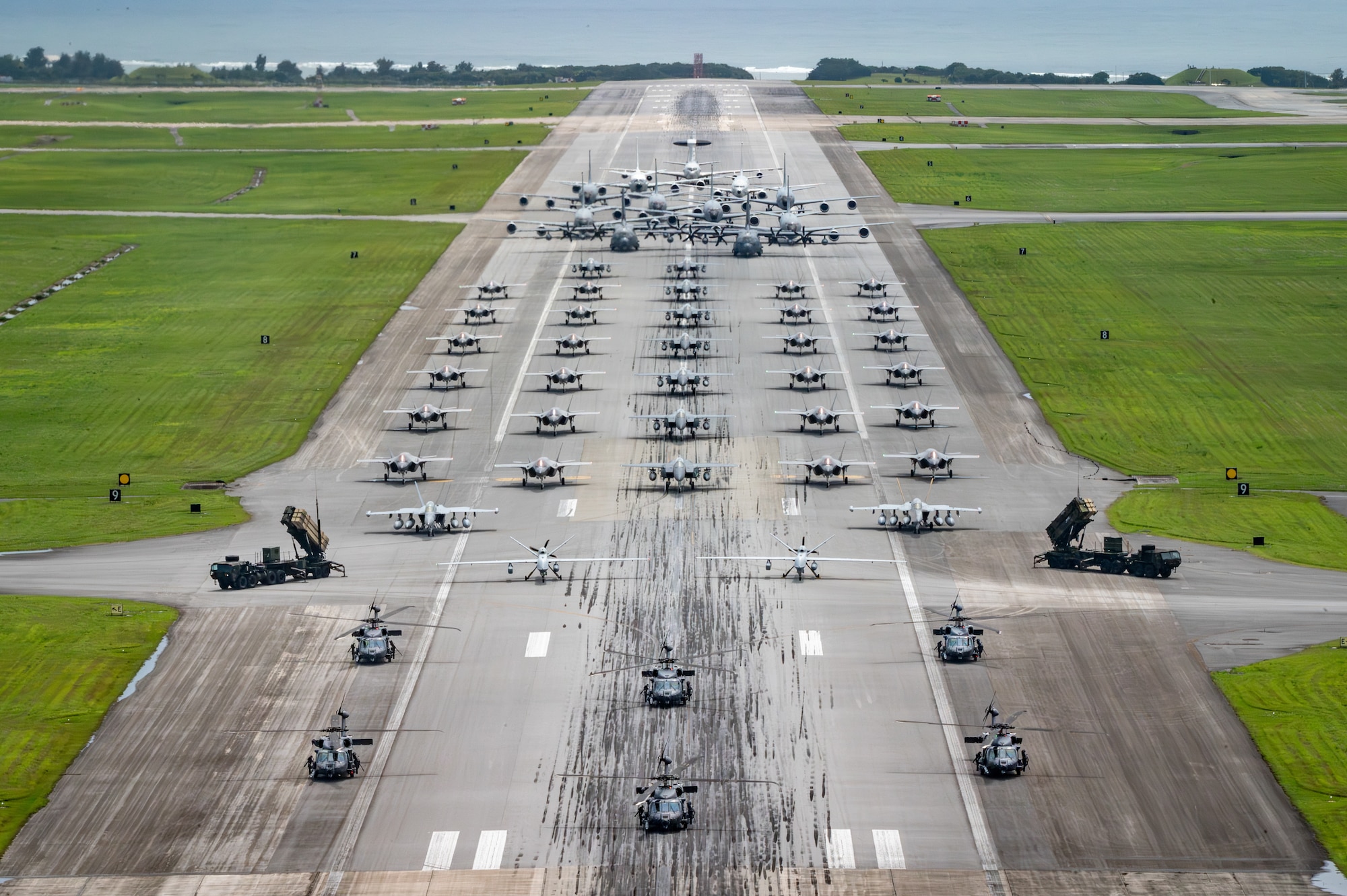 U.S. Air Force, Navy and Army assets line the runway for an elephant walk.