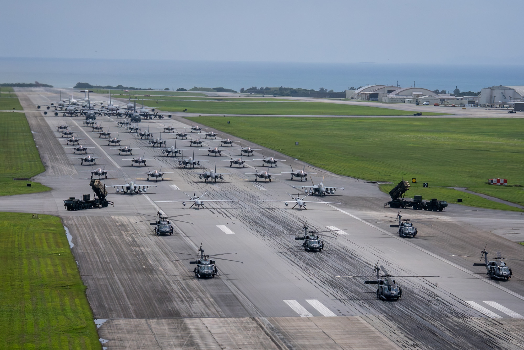 U.S. Air Force, Navy and Army assets line the runway for an elephant walk.