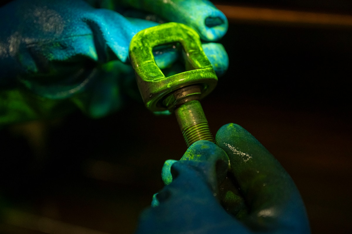 U.S. Air Force Airman Alejandro Ramirez, 35th Maintenance Squadron nondestructive inspection specialist, examines a part for defects.
