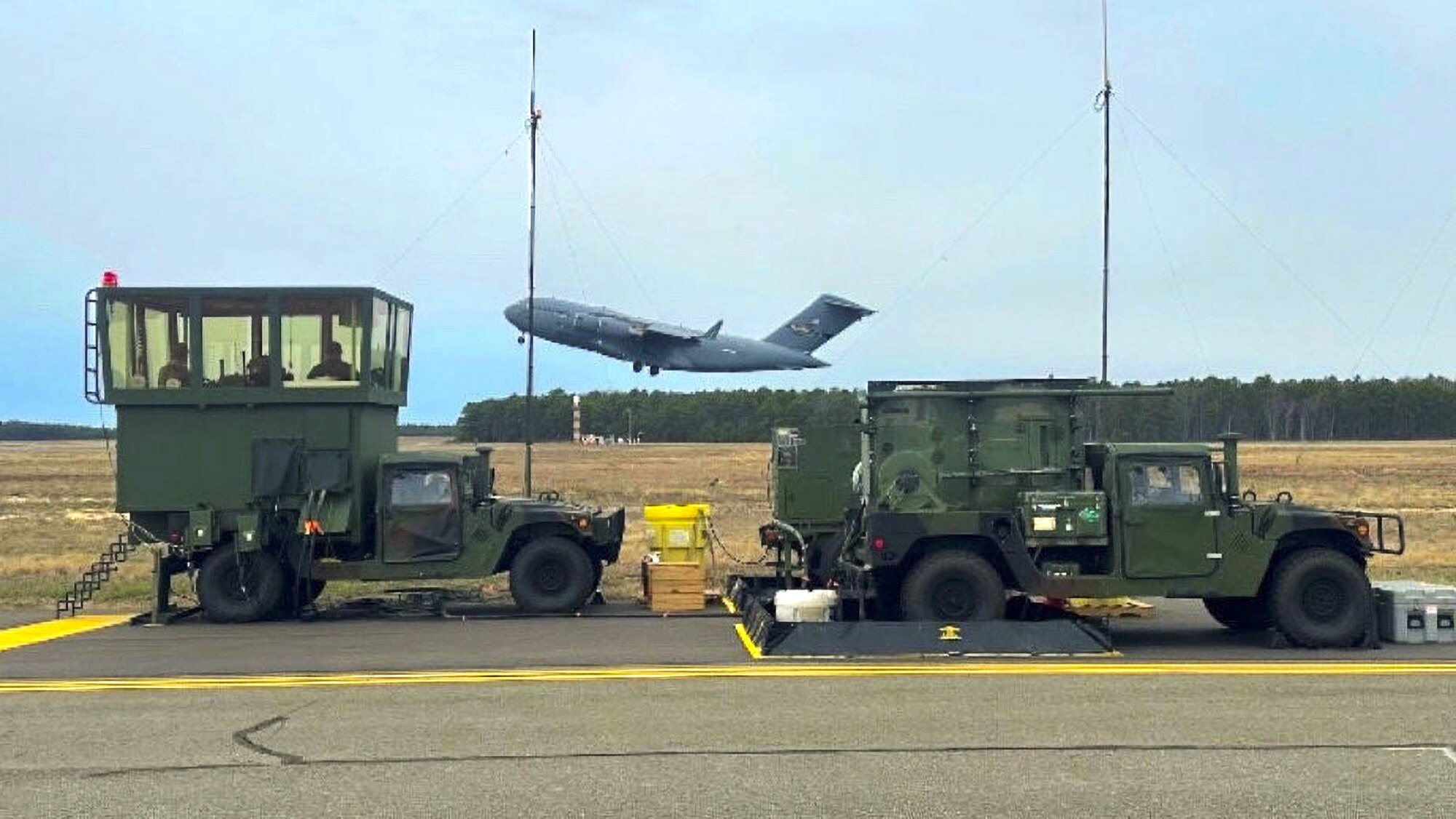 A C-17A Globemaster III aircraft takes off at Lakehurst’s Maxwell Field assisted by tower controllers inside the Mobile Special Navigational Aid-7 tower at Joint Base McGuire-Dix-Lakehurst, N.J., April 8, 2025. In a display of Total Force Integration, active-duty Airmen, Sailors and Air National Guard teams successfully deployed and activated the MSN-7 tower at Lakehurst’s Maxwell Field while the main tower underwent refurbishment allowing for uninterrupted support to mission readiness and operational capability. (U.S. Air Force photo by Tech. Sgt. Michael Sabo)